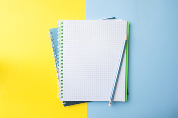 Clean white notebook and pencil with copy space on yellow blue table background for presentation, writer or school education, blogger, novel and friction or brand story concept.