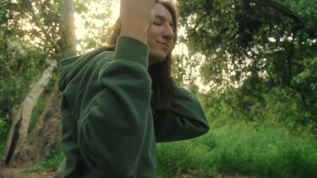 portrait shot of girl in the senery forest swinging on the swings with closed eyes