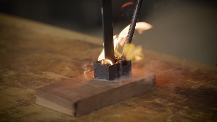 Branding with hot forged metal flames close up slow motion