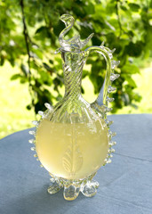 Homemade lemonade in a vintage carafe with lemons.
