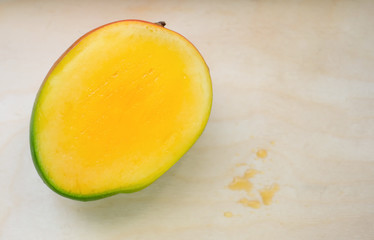 Ripe yellow exotic mango sliced on wooden background with drops of juice. Tropical delicacy full of vitamins for a healthy diet.