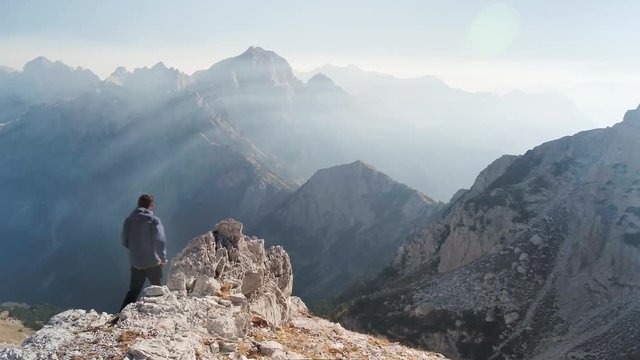Incredible views in the Albanian Alps as a man stands to witness the beauty! Summer's day in Albania in the mountains while hiking