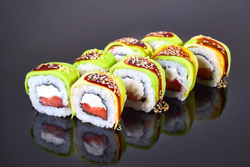 Philadelphia roll sushi with salmon, avocado, and cream cheese on black background for menu. Japanese food