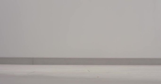 Woman in black high heels and black nylons walks slowly through frame; close up.
