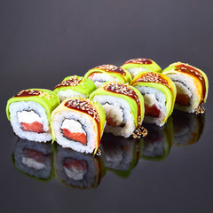 Philadelphia roll sushi with salmon, avocado, and cream cheese on black background for menu. Japanese food