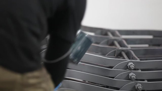 Behind view close up of an air brusher at work in a spray booth.