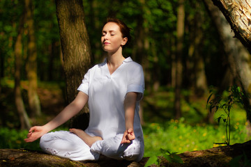 Beautiful girl practices yoga in peaceful nature atmosphere