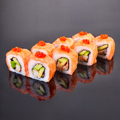 Philadelphia roll sushi with salmon, avocado, red caviar and cream cheese on black background for menu. Japanese food
