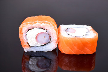 Philadelphia roll sushi with salmon, crab sticks and cream cheese on black background for menu. Japanese food