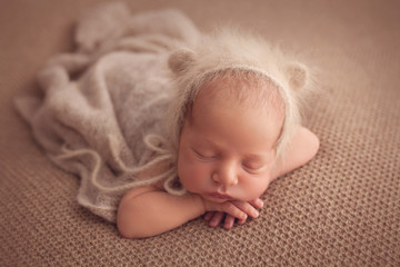 Cute sleeping newborn baby boy in beige color