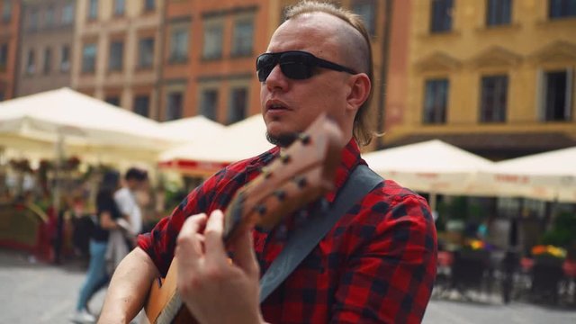 Stylish latin musician performing on streets with passion, close up shot