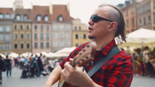 Male Street Musician, Busker Plays Acoustic Guitar And Sings.