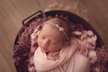 Sleeping newborn baby girl on pink background