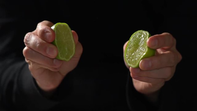 CU SLOW MOTION: Chef Squeezes A Lime In Each Hand, Makes Juices Squirt Out