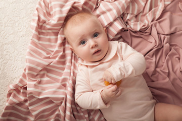 The three-month girl lies in a wicker basket with pink diaper