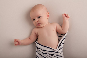 Portrait of a two-month boy on a bed with a diaper