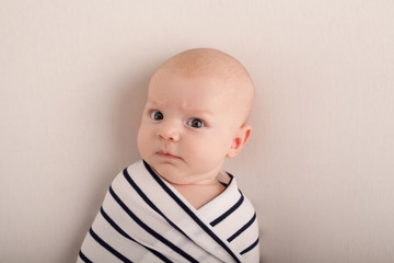 Portrait of a two-month boy on a bed with a diaper