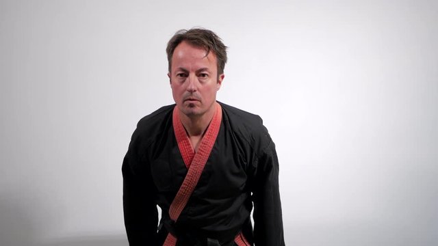 Male black belt martial artist performs the ready position before a starting a kata.