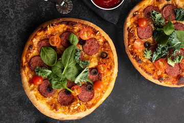 Freshly baked homemade pizza on a black background. View from above.
