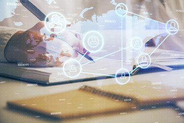 Fototapeta premium Social network theme hologram over hands taking notes background. Concept of global international people connect. Double exposure