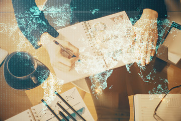 Social network theme hologram over hands taking notes background. Concept of global international people connect. Double exposure