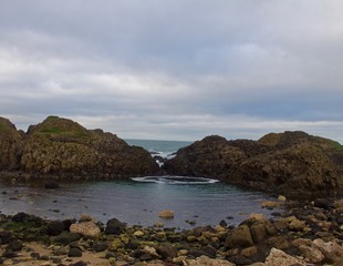 Fototapeta na wymiar Blue Tidal Pool Surrounded by Rocks on Irish Beach