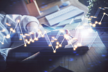 Financial forex charts displayed on woman's hand taking notes background. Concept of research. Double exposure