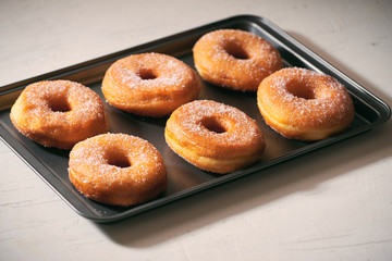Fried Donuts with Powdered Sugar on metal baking dish