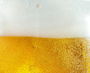 Close up view of floating bubbles in light golden colored beer background. Texture of cooling...