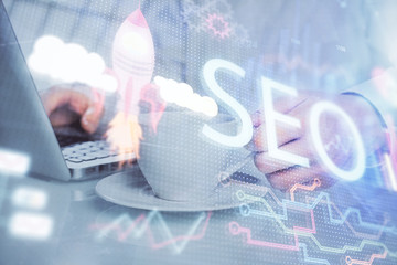 Multi exposure of seo icon with man working on computer on background. Concept of search engine optimization.