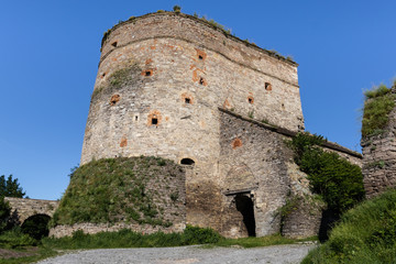 Fototapeta na wymiar Stone fort with loopholes, partly covered with greenery - part of the medieval fortifications of Kamianets-Podilskyi. Ukraine.