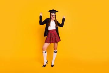 Full length body size view photo lady ecstatic raise fist scream close eye eyewear eyeglasses pigtail ponytail white pullover red skirt checked plaid long tails isolated yellow background black jacket
