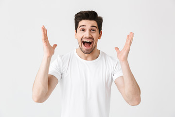 Excited happy young man posing isolated over white wall background.