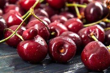 Close up, macro. Seasonal harvest of sweet cherries. Erotic berries. Dark wooden background.