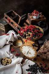 variety of currant berries on vintage kitchen scale on brown background