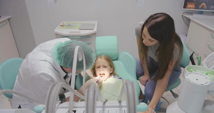 Mother cheering up daughter at dentist