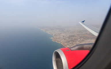Naklejka na ściany i meble View of the Mediterranean Sea and the coast of Tel Aviv city from the window of a flying airplane, Tel Aviv in Israel