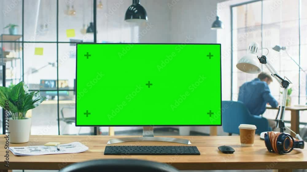 Aufkleber Wide Green Mock-up Screen Desktop Computer Standing on the Desk in the Modern Creative Office. In the Background High Ceiling Creative Loft for Developers and Designers where Professional Working.