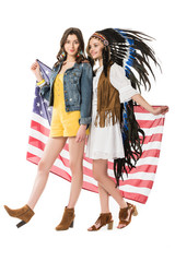 full length view of two bisexual hippie girls holding american flag isolated on white