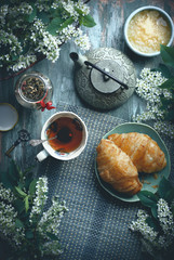 breakfast on table with tea, croissants and flowers, with copy space