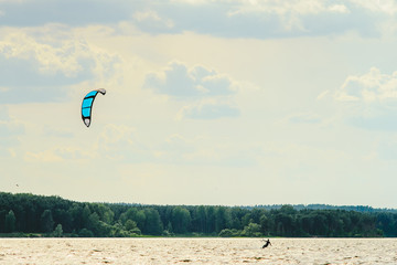 A kiteboarder is pulled across water by a power kite