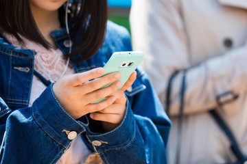 スマホを操作する若い女性の手元