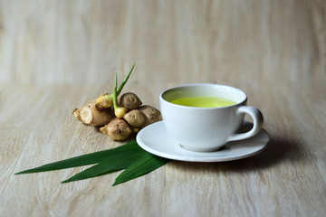 Ginger tea in a white cup on wooden background,Healthy drinks