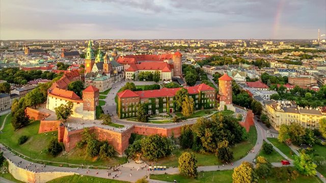 Historic royal Wawel Cathedral and castle in Cracow, Poland, in red sunset light with a rainbow, Vistula river, park and promenade. Aerial 4K approaching video at sunset in summer