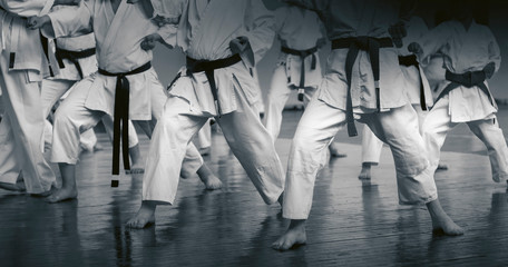Fototapeta na wymiar Kids training on karate-do. Banner with space for text. For web pages or advertising printing. Black and white photo without faces.