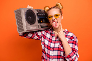 Close up photo nice she her nice lady toothy beaming smile vintage recorder shoulder horns symbol arm cool specs tongue out mouth wear casual checkered plaid pink shirt isolated orange background