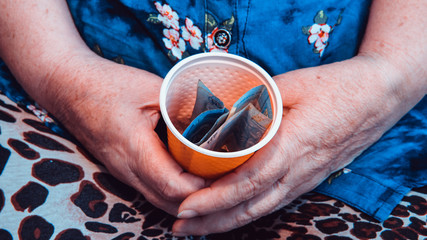 Old woman begs for alms. Closeup of money and coins in hand of poor woman.