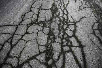 asphalt in cracks texture / abstract background cracks on asphalt road