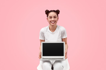 Cheerful teenager showing blank laptop