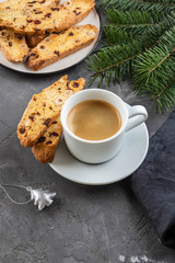 Traditional Christmas pastries, Italian homemade double-baked biscotti or cantuccini cakewith coffee, with nuts and dried fruits. with xmas decorations and fir branches.